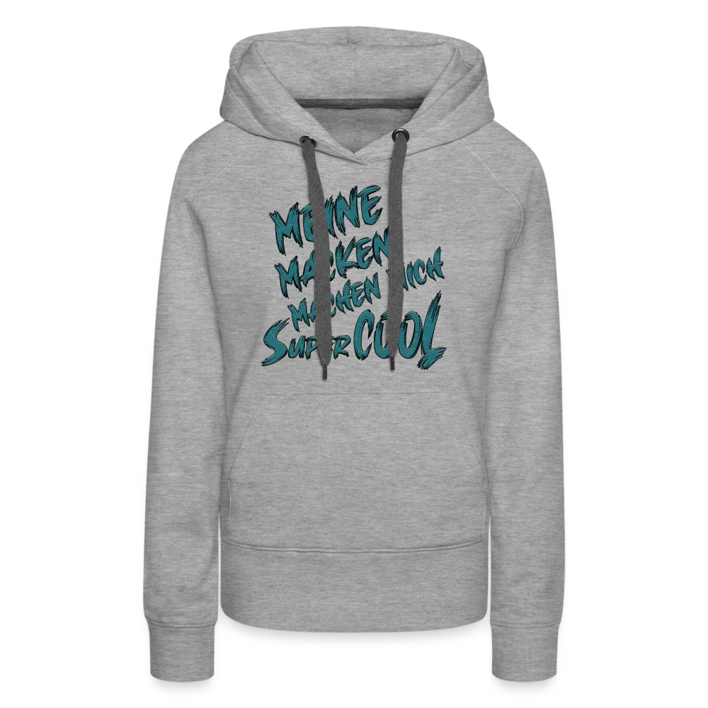 Grau melierter Streetwear Hoodie für Frauen mit dem Spruch auf den Brust „Meine Macken machen mich super cool“. Stilvolle Typografie, lustige Sprüche, mit kontrastfarbigen Kapuzenband und praktischer Kängurutasche. Perfekt für Alltag und Freizeit.