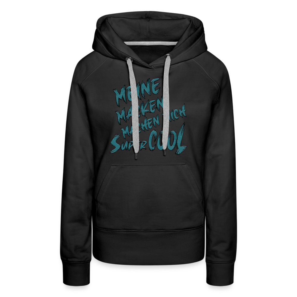 Schwarzer Streetwear Hoodie für Frauen mit dem Spruch auf den Brust „Meine Macken machen mich super cool“. Stilvolle Typografie, lustige Sprüche, mit kontrastfarbigen Kapuzenband und praktischer Kängurutasche. Perfekt für Alltag und Freizeit.